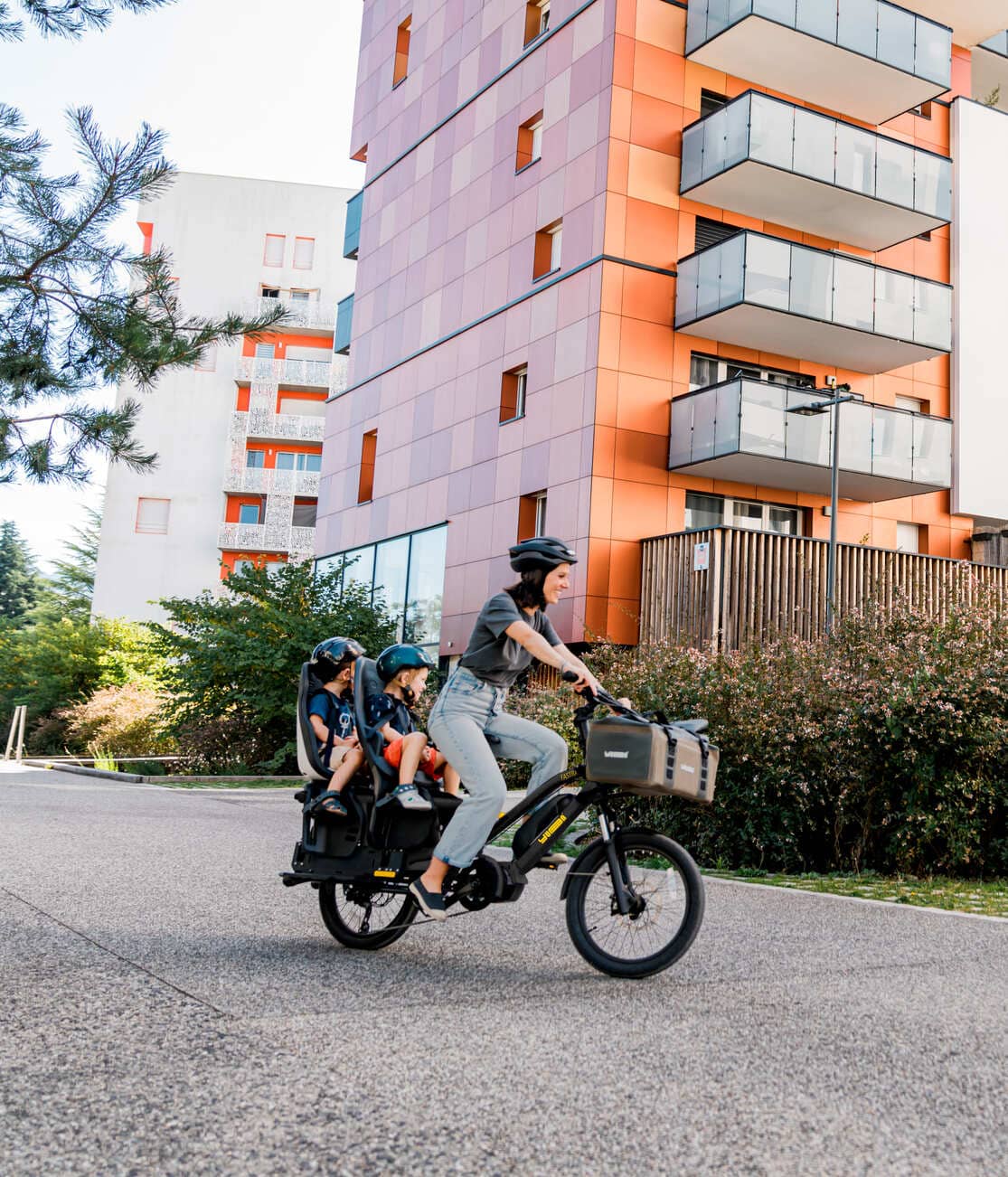 Maman avec deux enfants sur le vélo cargo compact électrique Yuba FastRack
